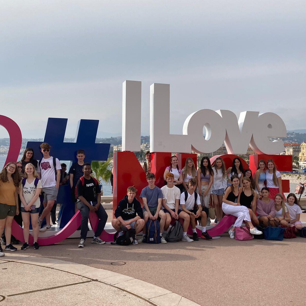 Students stood in front of an ilovenice symbol