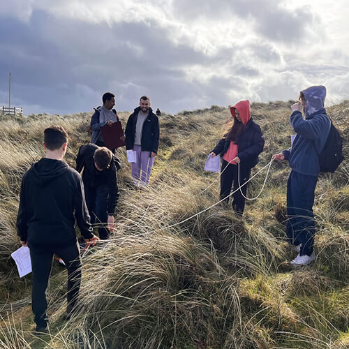 Students outdoors in long grass