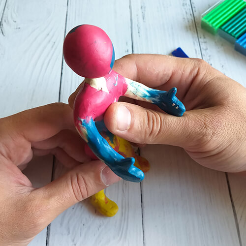 Hands making a body in clay
