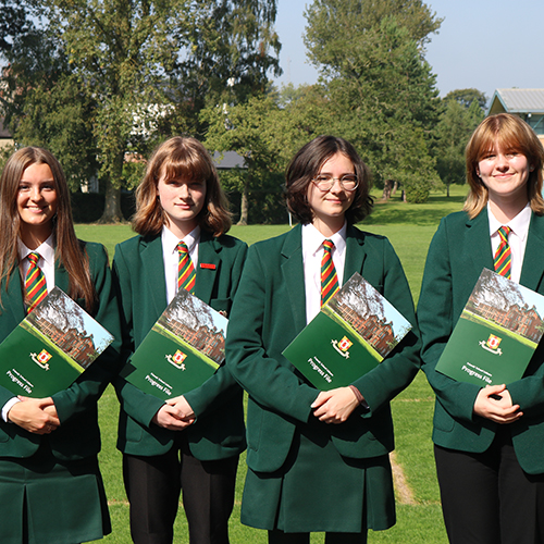 3 students holding a prospective brochure