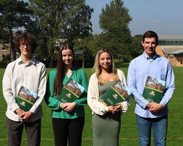 4 persons holding a brochure