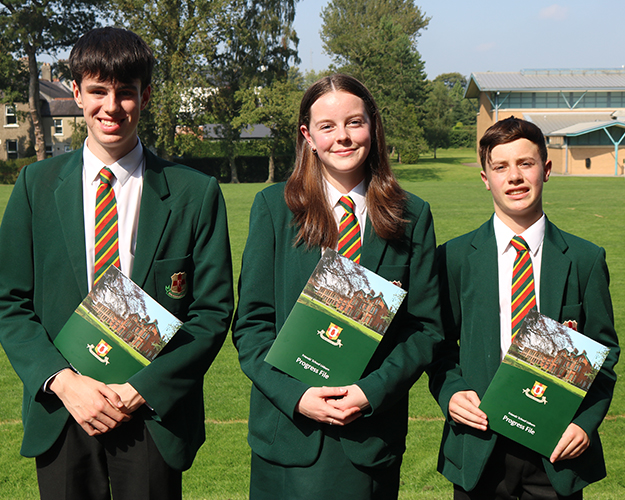 3 students holding a prospective brochure